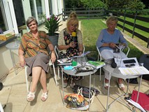 Grażyna Piekarewicz, Krystyna Pilecka, Stanisława Schreuder siedzą przy stolikach. Czyta Krystyna Pi