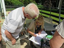 Krystyna Pilecka składa autograf w tomiku dla Zenona Kasprzaka.