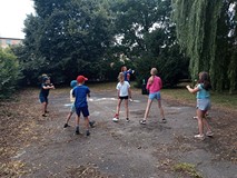 Dzieci i prowadząca tańczą w ogrodzie ZUMBĘ