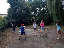 Dzieci i prowadząca tańczą w ogrodzie ZUMBĘ