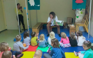 Bibliotekarka pokazuje dzieciom książkę