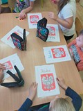 Dzieci podczas zajęć plastycznych kolorują godło Polski