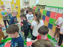 Grupa sześciolatków układa flagę Polski z małych karteczek