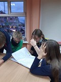 Na zdjęciu młodzież przeglądająca materiały przygotowane do druku sprzed pandemii