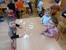 Dzieci układają z puzzli godło Polski