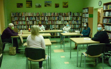 na zdjęciu uczestnicy spotkania, siedzą przy stole i rozmawiają