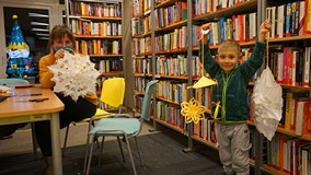 Uczestnicy warsztatów prezentują zrobione przez siebie ozdoby.