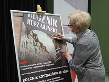 Iwona Sławińska podpisuje plakat.