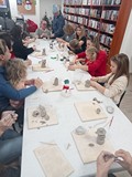 Uczestnicy warsztatów ceramicznych w Manowie tworzą bałwanki.