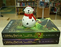 na zdjęciu książki ułożone na stos, od dołu J. K. Rowling 