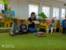 Bibliotekarka prezentuje dzieciom książkę.