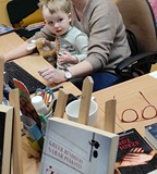 Chłopiec na kolanach bibliotekarki.