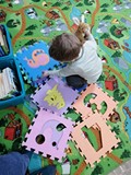 Chłopiec bawi się piankowymi puzzlami.