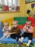 Dzieci siedzą na piankowej macie.