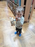 Chłopiec przy regałach z książkami.