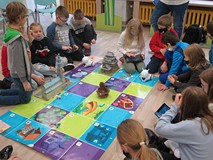 Bibliotekarz Maciej pokazuje uczestnikom jak programować roboty.