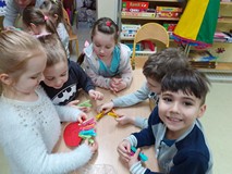 Dzieci przypinają klamerki do tekturowych dinozaurów.