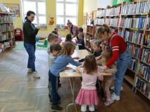 Dzieci pracuja przy stolikach, robią bociana z wacików kosmetycznych.