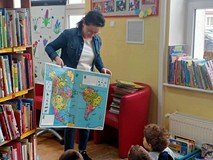 Bibliotekarka prezentują największą ksiązkę w bibliotece.