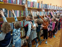 Dzieci przy regałach z książkami