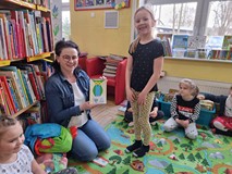 Bibliotekarka prezentuje laurkę podarowaną przez dzieci.