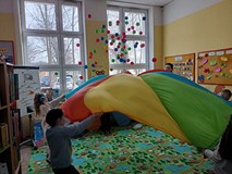 Dzieci podczas zabawy chustą integracyjną.