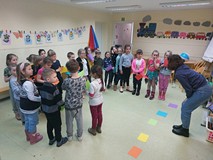 Dzieci stoją i trzymają w rękach kolorowe kartki