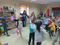 Dzieci podczas zajęć ruchowych, tańczą trzymająć kolorowe kartki