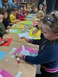 Dzieci wykonują prace plastyczne przy stolikach