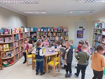 Dzieci w czytelni przeglądają książeczki, grają w gry i układają puzzle