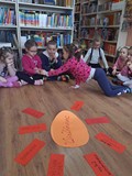 Dzieci w kręgu rozmawiają o tradycjach wielkanocnych i oglądają pisankę