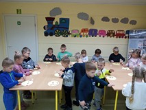 Dzieci podczas zajęć plastycznych, siędzą przy stole i przyklejają kolorewe karteczki