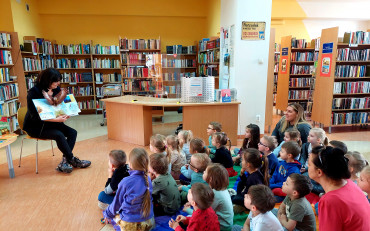 Pani Wiola prezentuje siedzącym na chuście animacyjnej przedszkolakom najpiękniejsze...