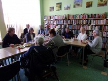 na zdjęciu uczestnicy spotkania, siedzą przy stole i rozmawiają