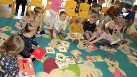 grupa dzieci ogląda książeczki