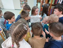 Dzieci czytają wskazówkę w grze terenowej