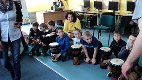 Bibliotekarka wspiera dzieci podczas gry na bębnach
