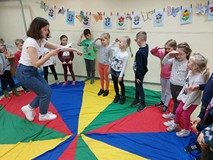 Dzieci podczas zabawy ruchowej, stoją w kole i podskakują