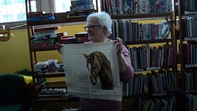 Pani pozuje do zdjęcia ze swoją pracą