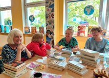 Książki do wypożyczenia wybrane - przed uczestniczkami spotkania leżą stosiki nowości