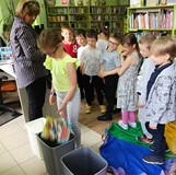 Dziewczynka wrzuca śmieci do odpowiedniego pojemnika
