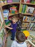 Dzieci w czytelni przeglądają książeczki