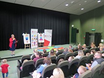 Powiatowe święto czytelnika dziecięcego w Koszalińskiej Bibliotece Publicznej. Prowadząca imprezę bi