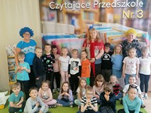 Przedszkolaki, które brały udział w spotkaniu, stoją w dwóch rzędach wraz z trzema nauczycielkami