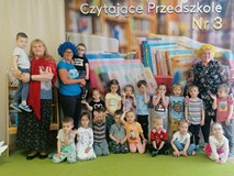 Przedszkolaki, które brały udział w spotkaniu, stoją w dwóch rzędach wraz z trzema nauczycielkami