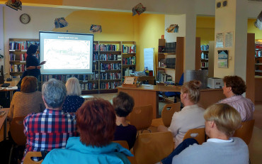 Pani Wiola prezentuje uczestniczkom spotkania zdjęcia starego Koszalina