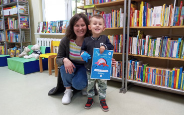 Bibliotekarka wraz z chłopcem trzymającym dyplom