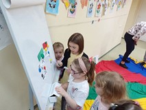 Dziewczynki przyklejają kartki do tablicy