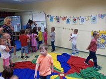 Dzieci przyklejają obrazki na tablicę