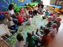 Bibliotekarka pokazuje dzieciom książeczkę